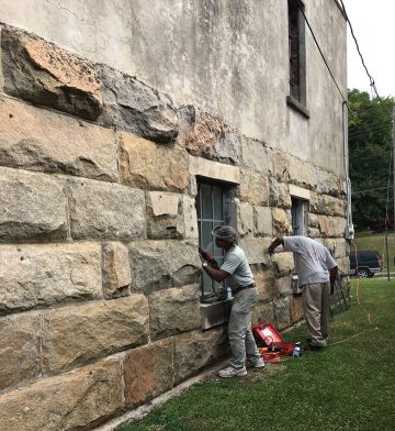 Joseph Spivey installs a new window